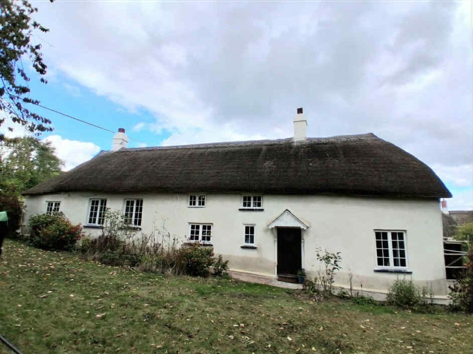 A thatched cottage finished in white render