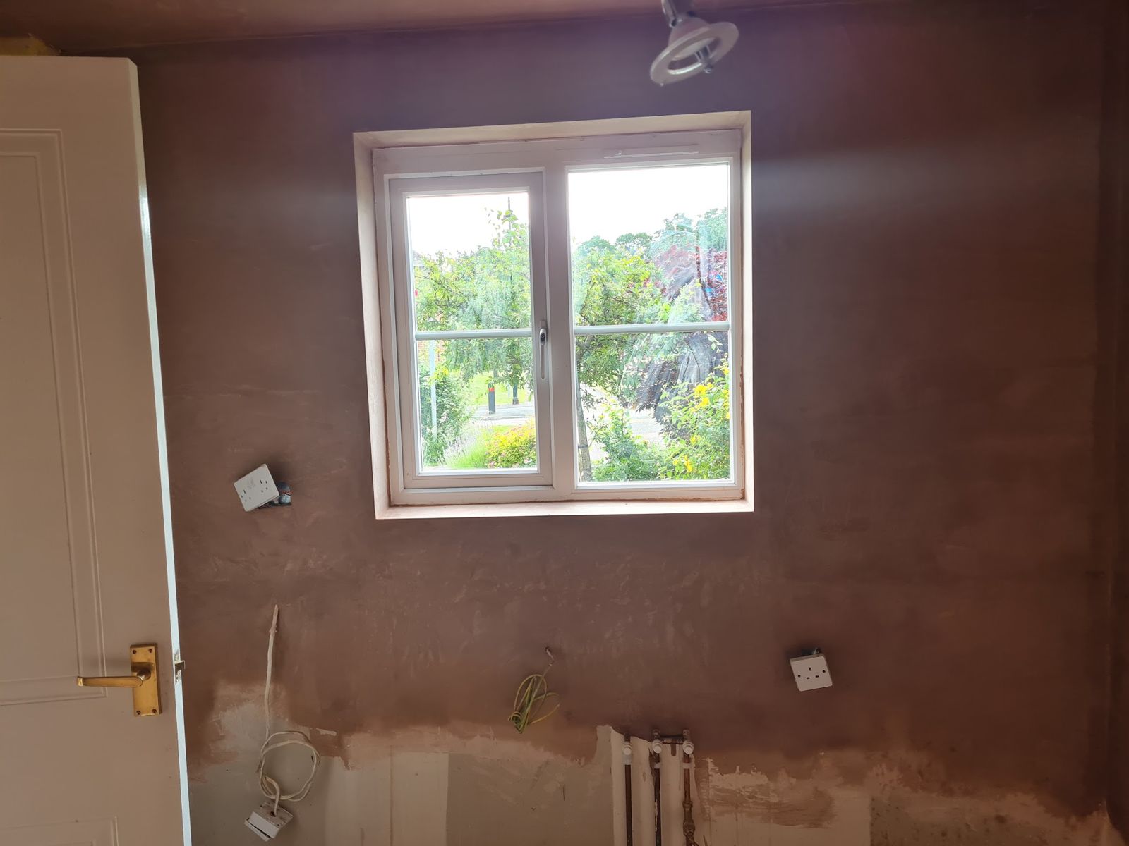 A freshly plastered kitchen wall around a window
